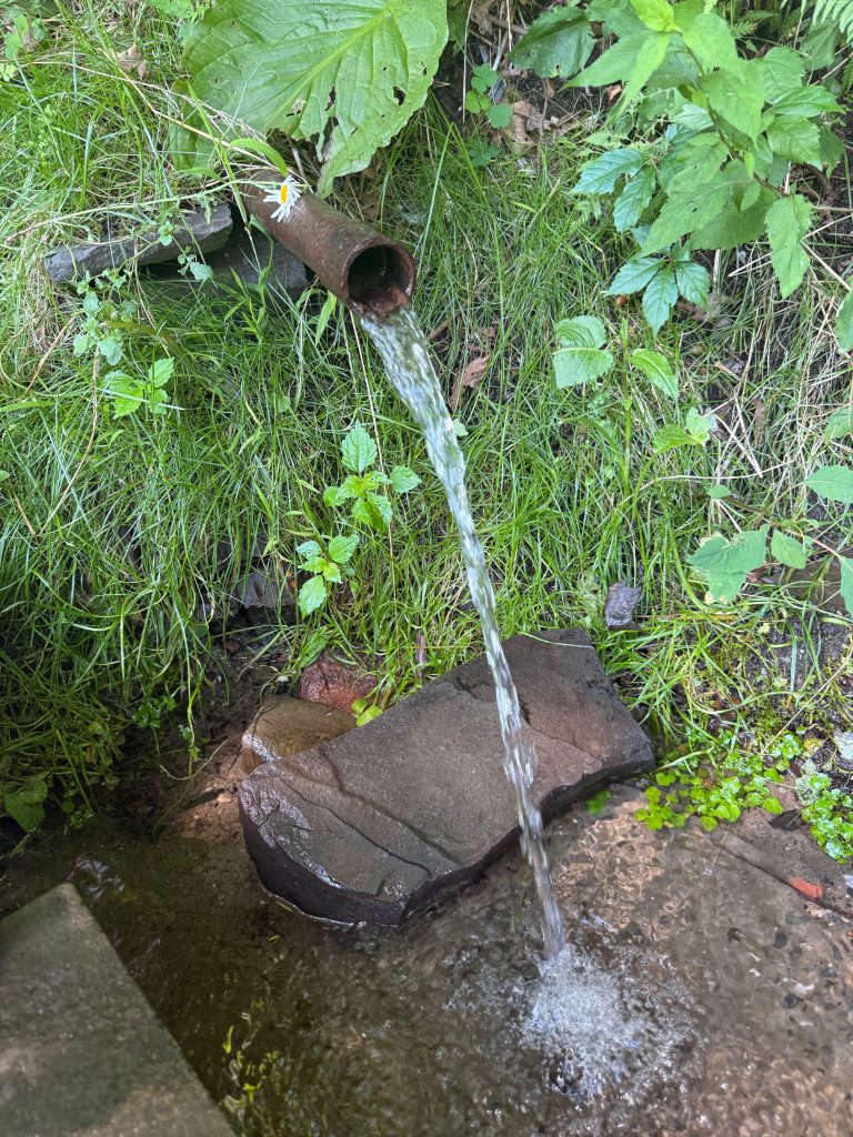 water flows from a pipe to pool on the earth
